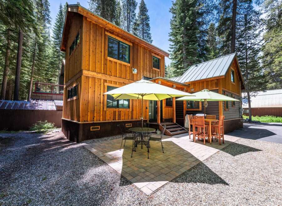 Enjoy outdoor living in this charming cabin nestled among tall pine trees.