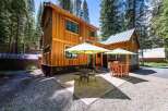 Enjoy outdoor living in this charming cabin nestled among tall pine trees.