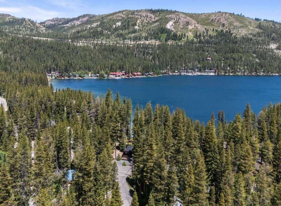 Nestled amidst a dense forest, this property offers a serene escape with stunning views of a vibrant blue lake.