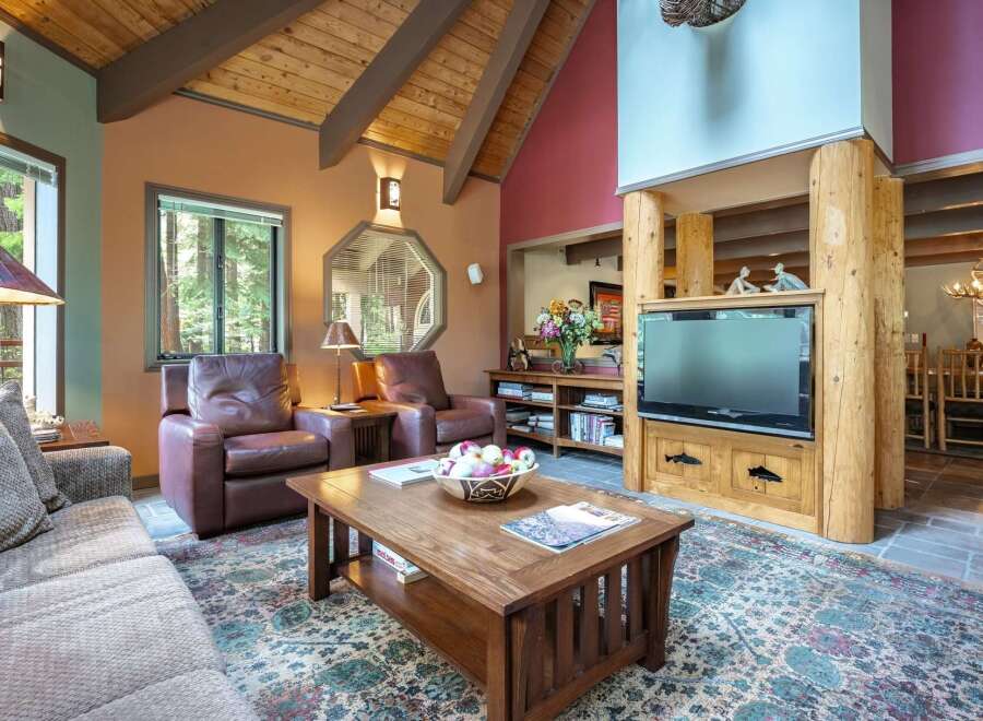 Experience rustic charm in this inviting living room, featuring plush leather armchairs and a comfortable sofa perfect for relaxation.