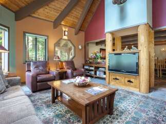 Experience rustic charm in this inviting living room, featuring plush leather armchairs and a comfortable sofa perfect for relaxation.