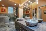 Experience luxury in this master bathroom, featuring a spacious walk-in shower with slate tile and a deep soaking tub.