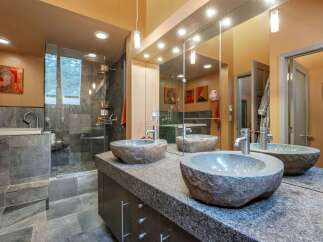 Experience luxury in this master bathroom, featuring a spacious walk-in shower with slate tile and a deep soaking tub.