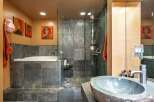 Experience luxury in this modern bathroom featuring a deep soaking tub and a spacious glass-enclosed shower with slate tile accents.