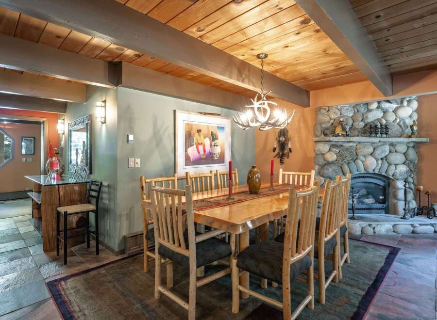 Experience rustic charm in this inviting dining room, featuring a solid wood table and chairs perfect for family gatherings.
