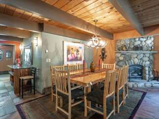 Experience rustic charm in this inviting dining room, featuring a solid wood table and chairs perfect for family gatherings.