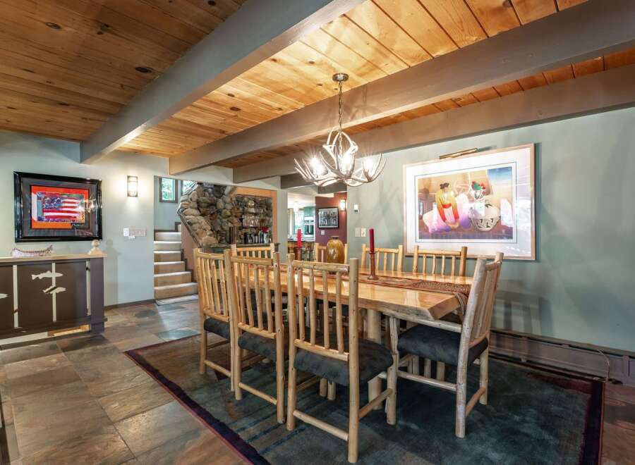 Experience rustic charm in this inviting dining room, featuring a stunning live-edge wood table paired with natural log chairs.