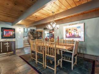 Experience rustic charm in this inviting dining room, featuring a stunning live-edge wood table paired with natural log chairs.