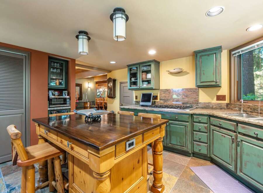 This spacious kitchen boasts a large wooden island with seating, perfect for casual dining and entertaining.
