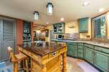 This spacious kitchen boasts a large wooden island with seating, perfect for casual dining and entertaining.