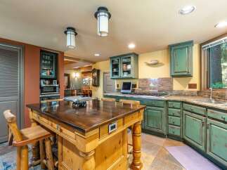 This spacious kitchen boasts a large wooden island with seating, perfect for casual dining and entertaining.