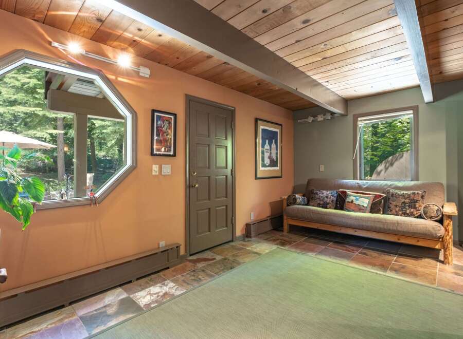 This inviting room features a unique octagonal window offering picturesque views of the surrounding greenery.