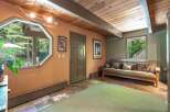This inviting room features a unique octagonal window offering picturesque views of the surrounding greenery.