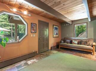 This inviting room features a unique octagonal window offering picturesque views of the surrounding greenery.