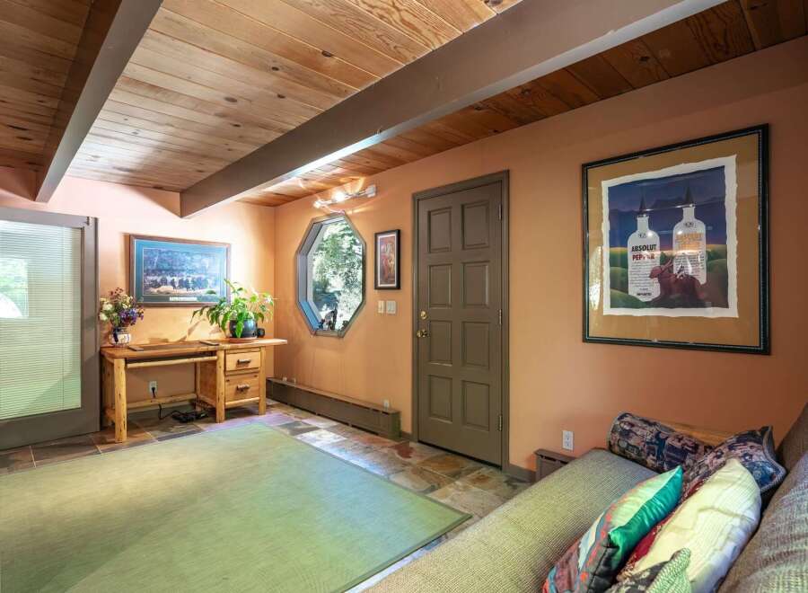 Discover a cozy and inviting space featuring a rustic wooden desk and a comfortable sofa, perfect for relaxation or work.