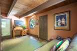 Discover a cozy and inviting space featuring a rustic wooden desk and a comfortable sofa, perfect for relaxation or work.