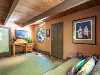 Discover a cozy and inviting space featuring a rustic wooden desk and a comfortable sofa, perfect for relaxation or work.