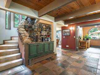 Discover rustic charm in this home featuring a stunning stone accent wall and a built-in bar area, perfect for entertaining.