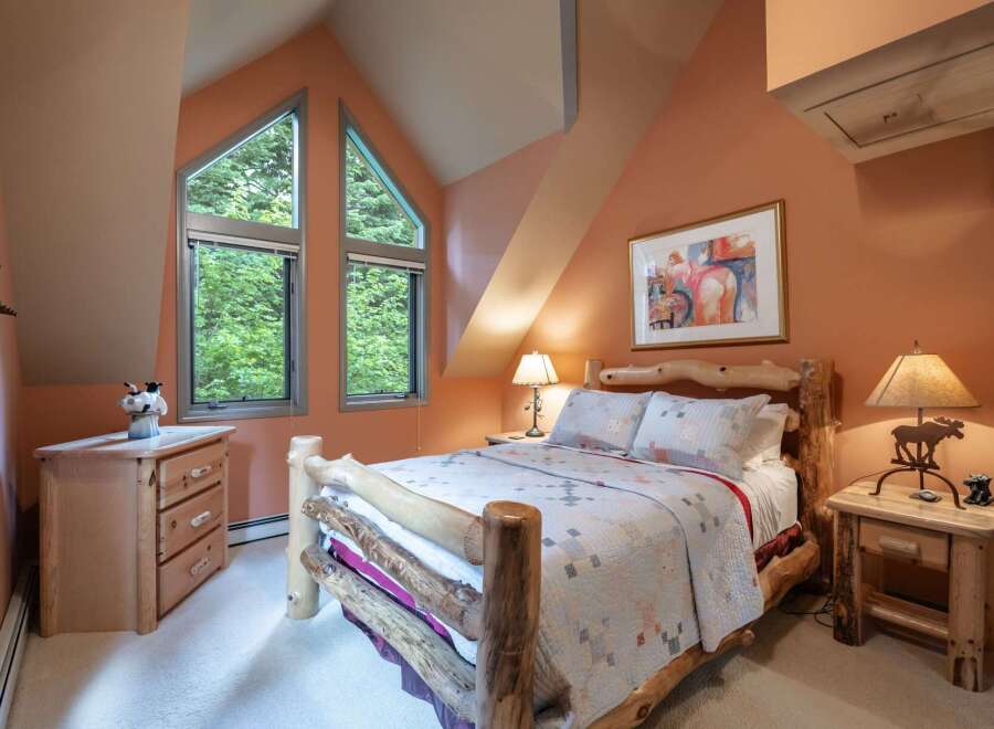Experience rustic charm in this cozy bedroom, featuring a unique log bed and a charming quilt.