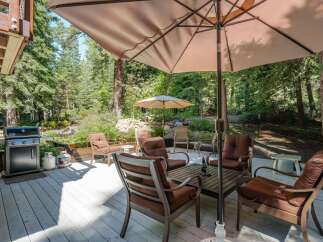 Enjoy outdoor living at its finest on this spacious deck, perfect for entertaining or relaxing amidst a serene wooded setting.