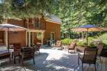 Enjoy outdoor living on this spacious wooden deck, perfect for entertaining or relaxing amidst a serene forest setting.