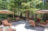 Enjoy the serene mountain lifestyle on this spacious deck, perfect for outdoor entertaining or quiet relaxation amidst towering pine trees.