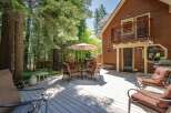 Enjoy outdoor living on this spacious wooden deck, perfect for entertaining or relaxing amidst a serene forest setting.