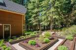 Discover a beautifully landscaped backyard featuring raised garden beds perfect for cultivating your own vegetables and flowers.