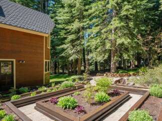 Discover a beautifully landscaped backyard featuring raised garden beds perfect for cultivating your own vegetables and flowers.