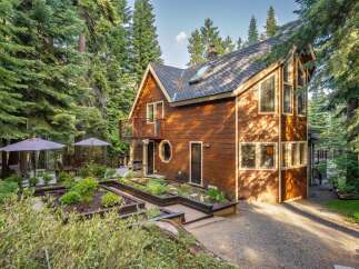 Nestled amidst towering pine trees, this charming wooden cabin offers a serene mountain retreat.