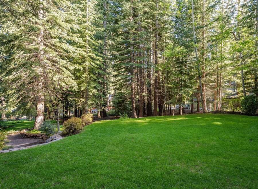 Enjoy the tranquility of this expansive backyard, featuring a lush, green lawn perfect for recreation and relaxation.