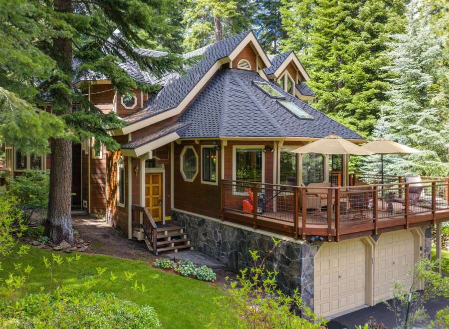Nestled amidst lush greenery, this charming wooden home offers a serene retreat with its expansive deck perfect for outdoor entertaining.