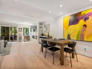 Experience modern living in this spacious open-concept home, featuring a sleek dining area perfect for gatherings and a cozy living space with a fireplace.