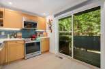 This modern kitchen features sleek, light wood cabinetry and a stylish geometric tile backsplash.