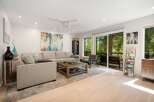 Experience modern living in this spacious living room, featuring a comfortable sectional sofa and a rustic wooden coffee table perfect for gatherings.