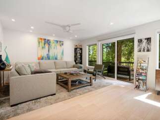 Experience modern living in this spacious living room, featuring a comfortable sectional sofa and a rustic wooden coffee table perfect for gatherings.