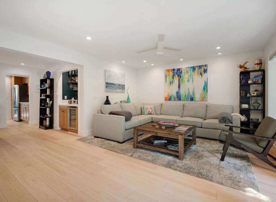 Experience modern living in this spacious open-concept living area, featuring a comfortable sectional sofa, a stylish coffee table, and vibrant abstract art.