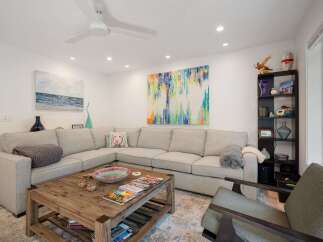 This spacious living room features a large sectional sofa perfect for family gatherings, complemented by a rustic wooden coffee table.