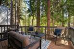 Enjoy the serene mountain lifestyle on this charming deck, perfect for relaxing amidst towering trees.