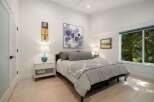 This inviting bedroom features a comfortable king-size bed adorned with plush grey bedding and a decorative throw.