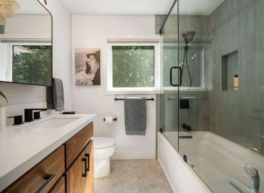 Experience modern luxury in this stunning bathroom, featuring a sleek vanity with ample storage and a minimalist aesthetic.