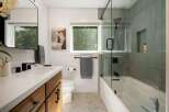 Experience modern luxury in this stunning bathroom, featuring a sleek vanity with ample storage and a minimalist aesthetic.