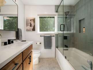 Experience modern luxury in this stunning bathroom, featuring a sleek vanity with ample storage and a minimalist aesthetic.