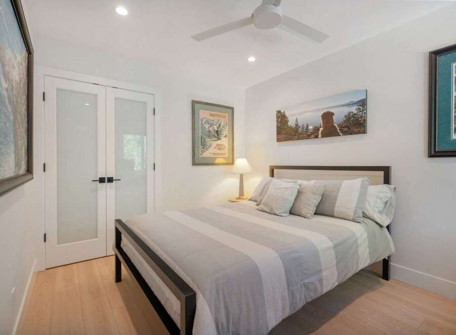 This inviting bedroom features a comfortable queen-size bed with a stylish striped comforter and plush pillows.