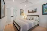 This inviting bedroom features a comfortable queen-size bed with a stylish striped comforter and plush pillows.
