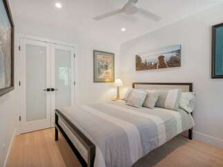 This inviting bedroom features a comfortable queen-size bed with a stylish striped comforter and plush pillows.