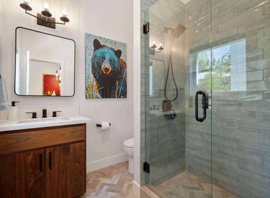 Experience modern comfort in this stylish bathroom, featuring a sleek vanity with ample storage and a striking black bear artwork.