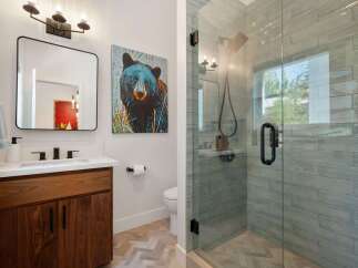 Experience modern comfort in this stylish bathroom, featuring a sleek vanity with ample storage and a striking black bear artwork.