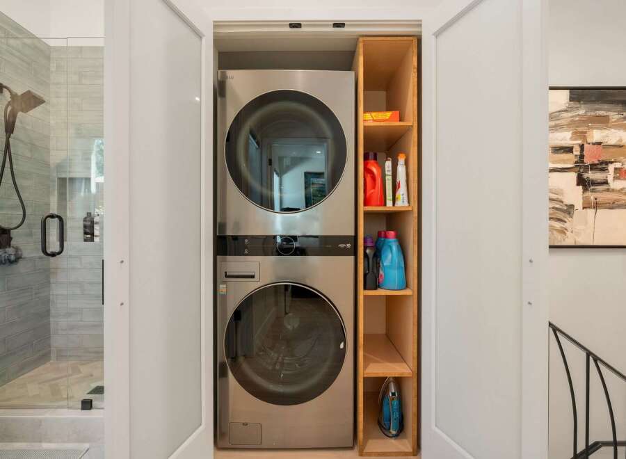 Discover the ultimate convenience with this stacked LG washer and dryer unit, perfectly integrated into a compact laundry space.