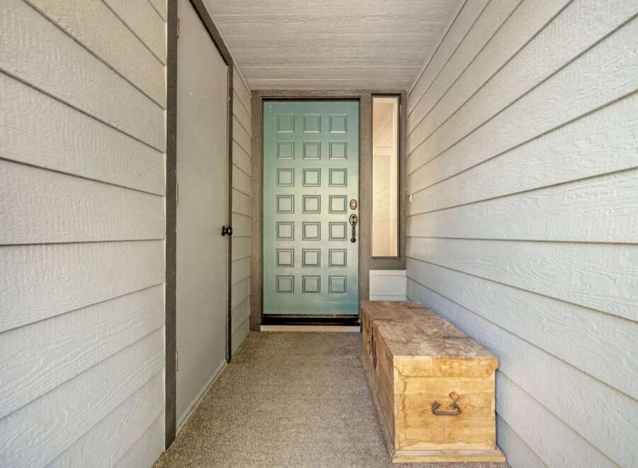 Step into this charming entryway featuring a light blue paneled door, perfect for welcoming guests.